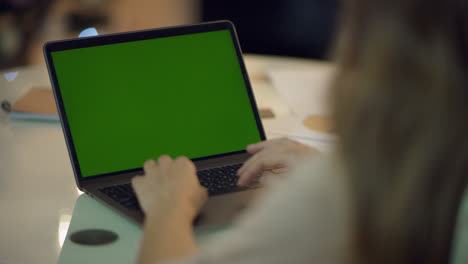 Woman-hand-typing-keyboard-of-laptop-computer-with-green-screen-at-home