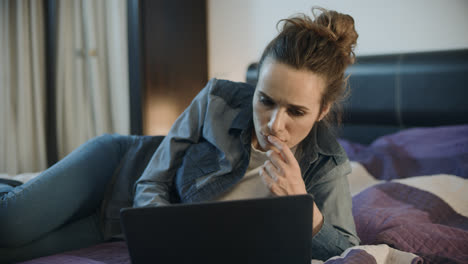 Young-woman-lying-with-laptop-computer-on-home-couch.-Lady-work-on-computer