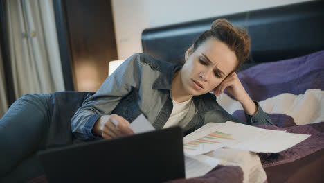 Thoughtful-woman-doing-paperwork-at-night.-Business-woman-working-with-papers