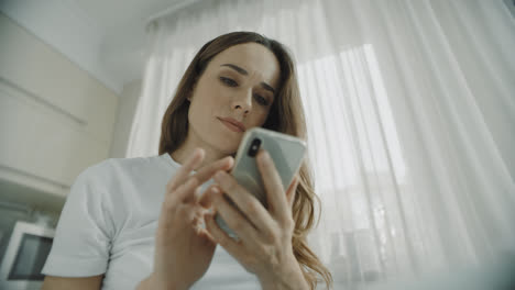 Young-woman-using-mobile-phone-at-home.-Close-up-of-girl-using-smartphone