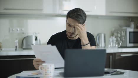 Thoughtful-man-working-with-documents-at-home.-Business-man-doing-paperwork