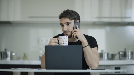 Businessman-drinking-coffee-and-talking-phone-at-home.-Business-man-call-mobile