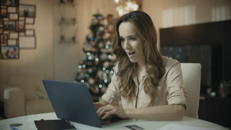 Mujer-Feliz-Usando-Computadora-Portátil-En-Casa-De-Navidad.-Mujer-De-Negocios-Viendo-Noticias