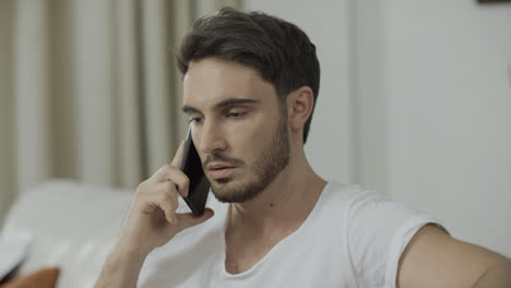 Serious-man-talking-mobile-phone-at-home.-Worried-business-man-call-phone