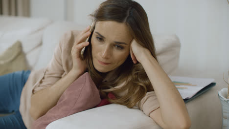 Woman-answer-phone-on-sofa-at-home.-Female-person-talking-mobile-on-couch