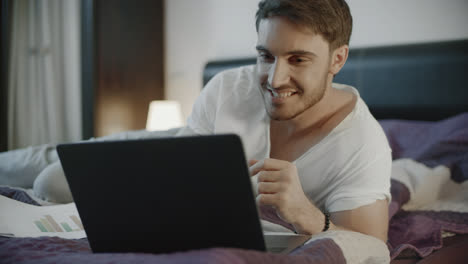 Happy-man-using-laptop-computer-at-home.-Smiling-man-chatting-online-on-notebook