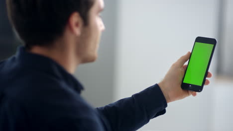 Close-up-male-professional-making-video-talk-on-green-screen-mobile-phone.