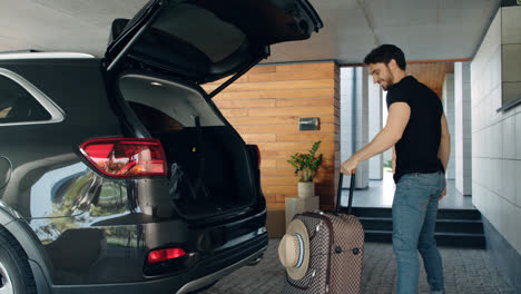 Handsome-man-taking-suitcase-from-car-in-luxury-house.-Rich-man-coming-home