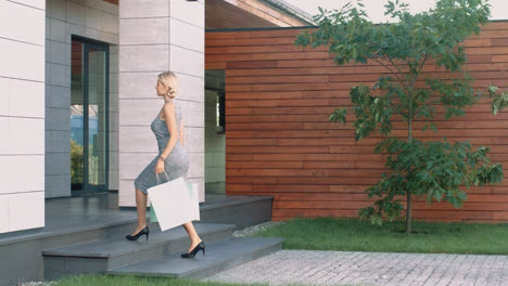 Woman-entering-luxury-apartments-with-shopping-bag.-Female-customer-coming-home