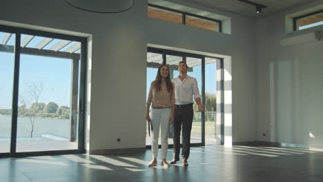 Happy-couple-entering-modern-home.-Cheerful-couple-buy-mortgage-home