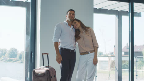 Happy-couple-with-bag-caming-back-home.-Travel-couple-with-suitcase
