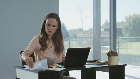Business-woman-working-at-laptop-computer.-Upset-lady-checking-documents.