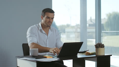 Business-man-working-at-laptop-computer.-Positive-freelancer-preparing-documents