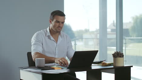 Business-man-working-at-laptop-computer.-Positive-freelancer-preparing-documents