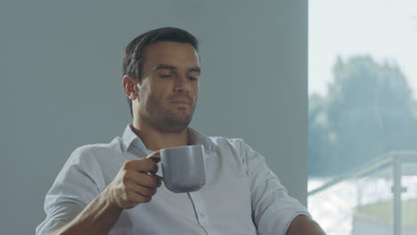 Business-man-finishing-working-day.-Closeup-portrait-of-male-drinking-coffee.