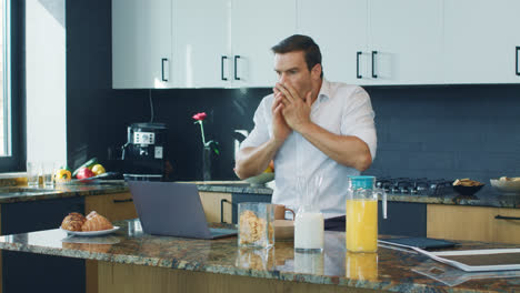 Business-man-watching-video-big-kitchen.-Shocked-man-looking-at-laptop-computer
