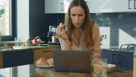 Business-woman-watching-video-in-big-kitchen.-Woman-getting-shocked-news