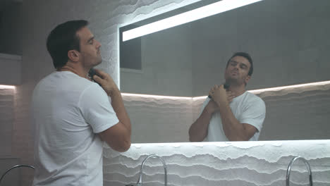 Sexy-man-shaving-beard-in-bath.-Grooming-of-serious-man-shaving-in-bathroom.