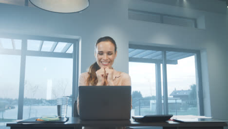 Happy-business-woman-receiving-good-news-on-laptop-computer-at-home