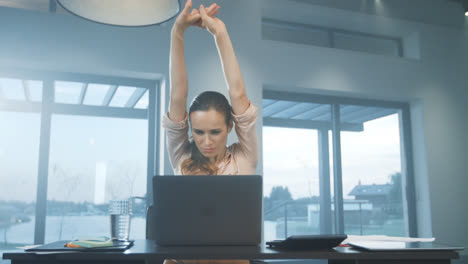 Business-woman-stretching-arms.-Tired-woman-relaxing-at-remote-workplace.