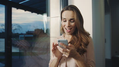 Relaxed-woman-getting-funny-message-on-mobile.-Happy-woman-chatting-on-cellphone