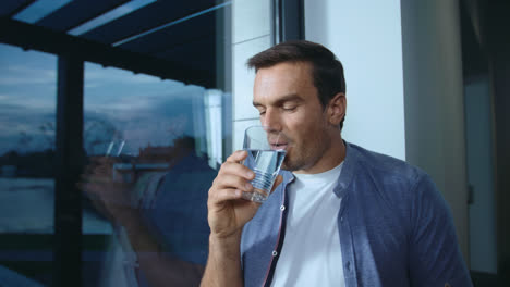 Entspannter-Mann-Trinkt-Wasser-Am-Fenster.-Durstige-Männliche-Person-Trinkt-Wasser.