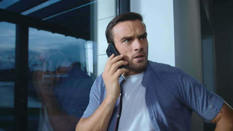 Business-man-yelling-on-mobile-in-house.-Closeup-shocked-man-talking-on-phone.