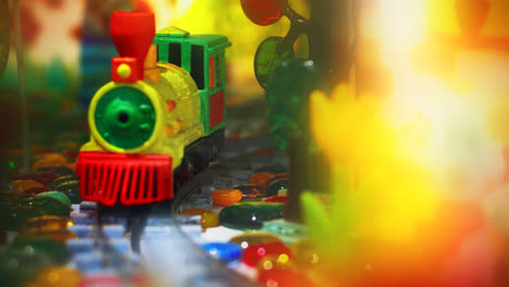 Colorful-toy-train-moving-by-rails-on-camera.-Close-up-kids-railroad