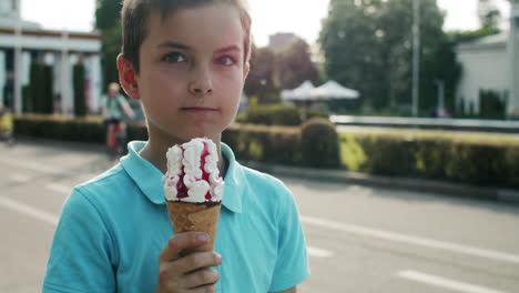 Close-up-ocute-boy-eating-ice-cream.-Relaxed-child-walking-in-amusement-park