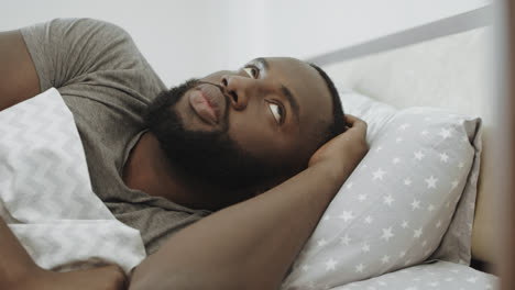 African-man-sleeping-in-bed-in-morning.-Unhappy-male-person-hating-morning.