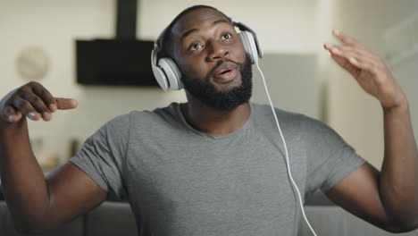 Black-man-singing-in-headphones.-Portrait-of-happy-guy-dancing-with-body
