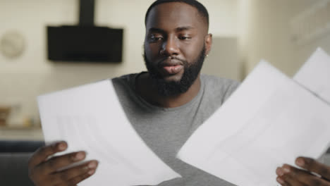 Black-man-checking-documents-at-workplace.-Business-man-analyzing-information.
