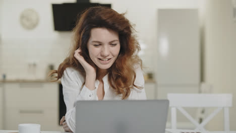 Smiling-woman-reading-joyful-news-in-laptop.-Happy-young-lady-looking-computer