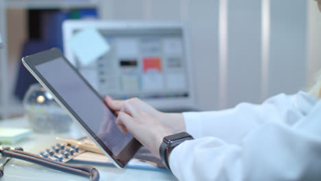Female-doctor-using-tablet-at-medical-workplace.-Nurse-using-tablet-pc