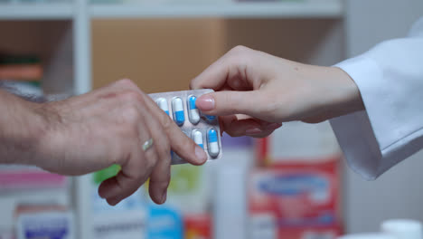 Pharmacist-hand-give-blister-pack-to-customer-hand.-Buying-medicaments