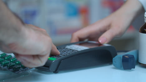 Man-buy-medicament-with-card-terminal-at-pharmacy.-Pos-terminal-at-medical-store