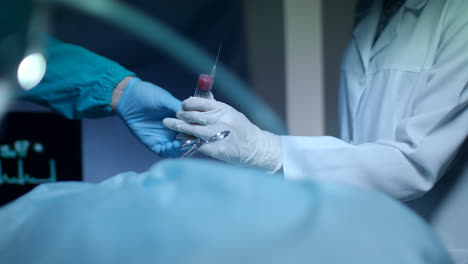 Surgery-hand-give-blood-syringe.-Surgery-hands-during-procedure