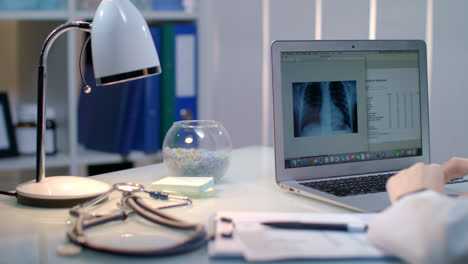 Doctor-working-with-xray-on-laptop-at-workplace.-Radiologist-check-x-ray-picture