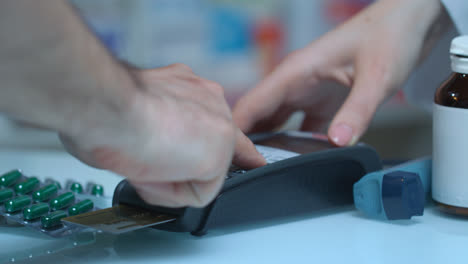 Male-hand-enter-password-on-pos-terminal-at-drugstore.-Credit-card-payment
