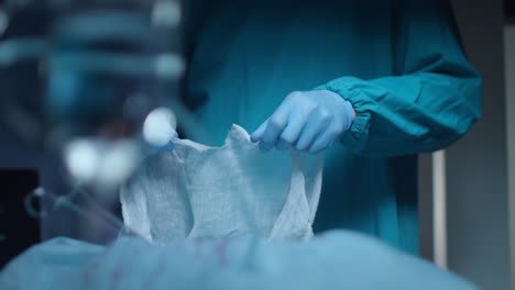 Surgeon-hand-tearing-gauze-at-surgeon-room.-Surgeon-prepare-medical-procedure