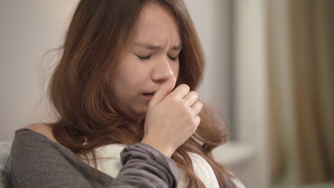 Sick-woman-sneezing-at-home.-Close-up-of-young-woman-sneeze-and-cough-in-bedroom