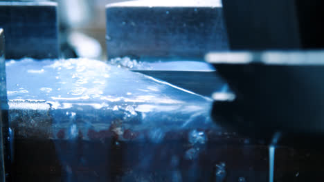 Coolant-splashes-fall-on-surface-of-metal-during-sawing-on-metalworking-machine
