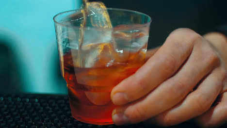 Barkeeper-Bereitet-An-Der-Bar-Einen-Cocktail-Mit-Alkohol-Und-Eis-Im-Glas-Zu