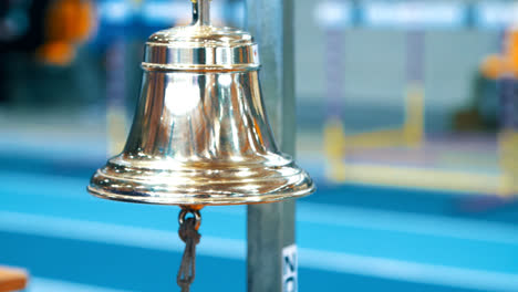 Referee-ringing-bell-at-finish-of-competition.-Sports-handbell-closeup