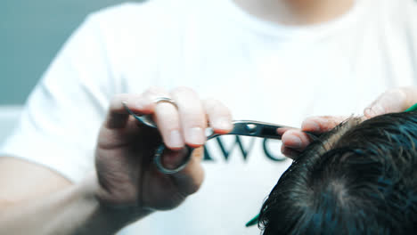Hairdresser-with-scissors-and-comb-making-stylish-male-hairdo