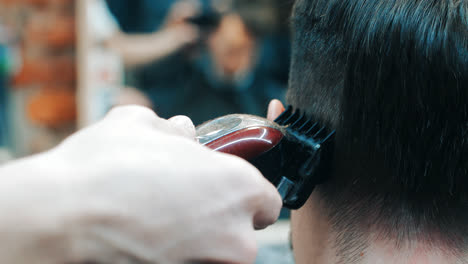 Friseur-Macht-Einem-Mann-Mit-Einer-Elektrischen-Haarschneidemaschine-Im-Friseursalon-Eine-Frisur