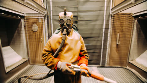 Worker-in-chemical-rubber-suit-and-respirator-in-chemical-processing-plant