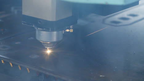 Laser-cutting-of-metal-sheet-with-sparks.-Industrial-equipment-at-plant