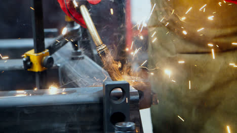 Experienced-welder-holding-lead-tip-of-welding-gun-during-weld-process