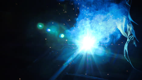 Stream-of-bright-sparks-from-industrial-metal-cutting.-Blue-flame-and-sparks